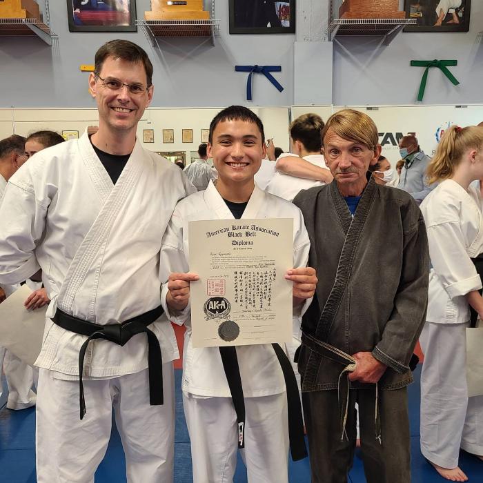 My first black belt student (middle) with his rank certificate from my sensei, John Sharkey (circa 2020).